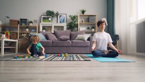a woman and a child sitting on a rug in a living room